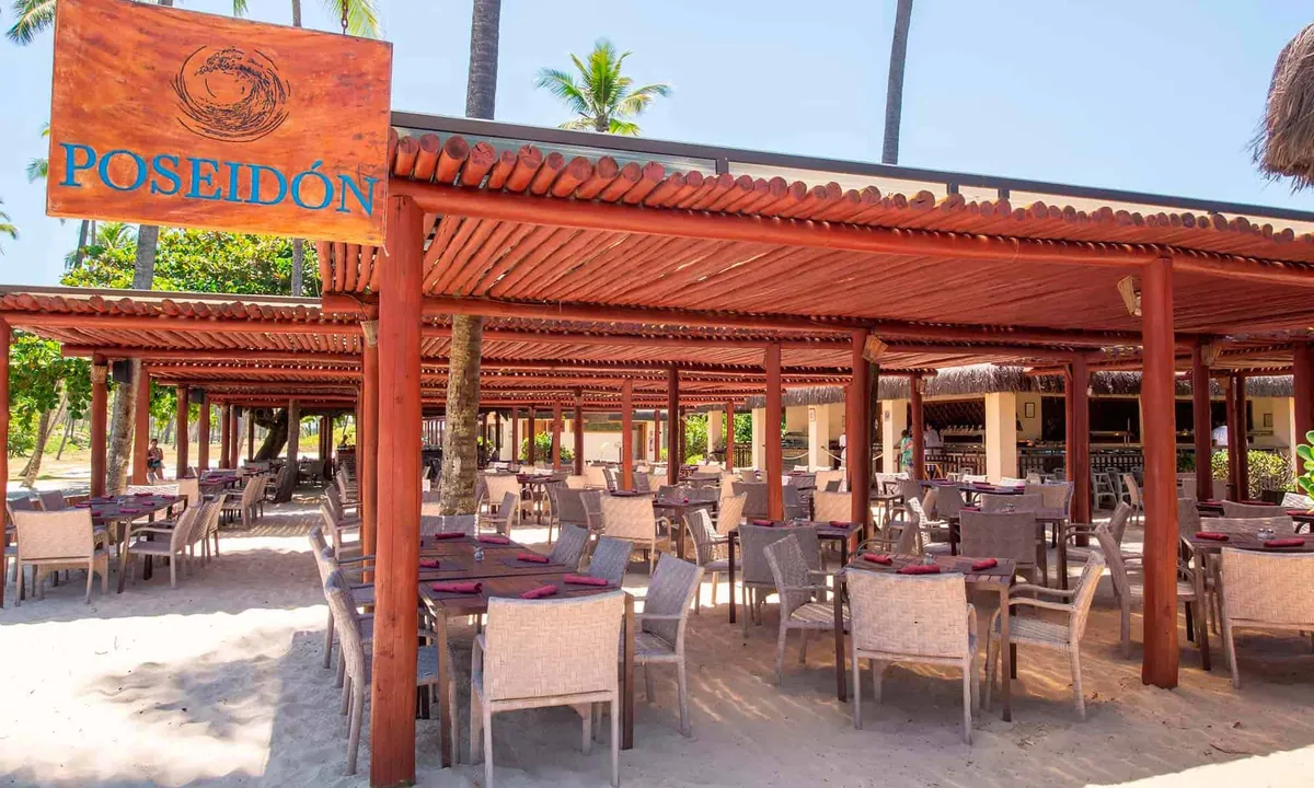Restaurante Poseidon com mesas na areia, na praia do resort
